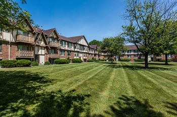 an apartment building with green grass and trees at Polo Run Apartments, Greenwood